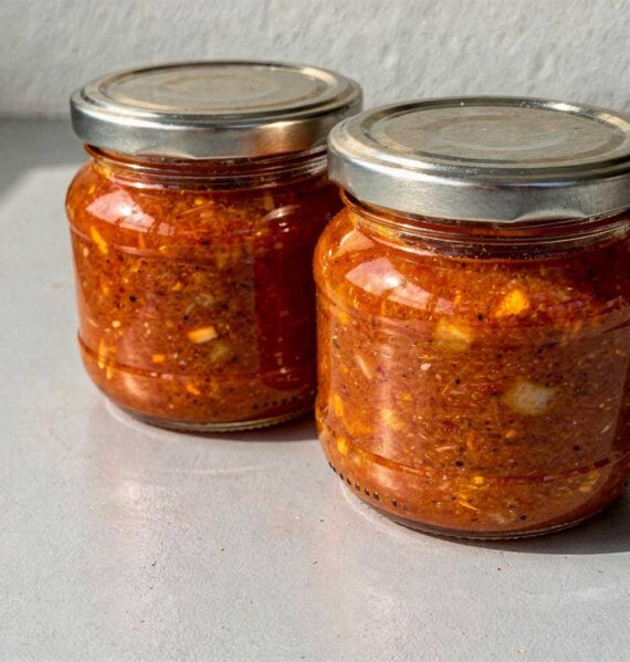 2 grote inmaakpotten met daarin mandarijn tomaten chutney.