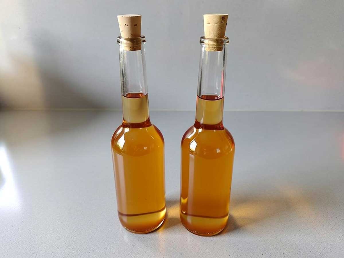 2 flesjes met zelfgemaakte heldere appelazijn.