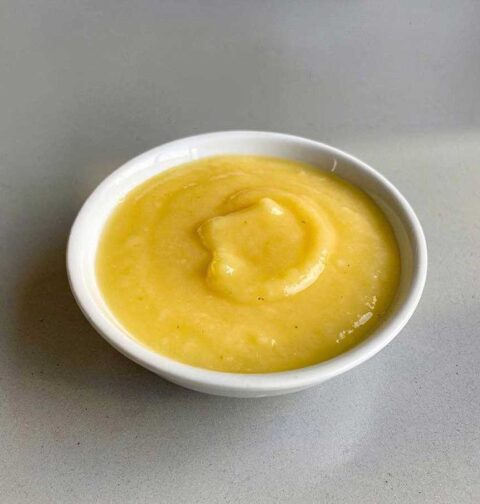 Een wit schaaltje met zelfgemaalt lemoncurd.