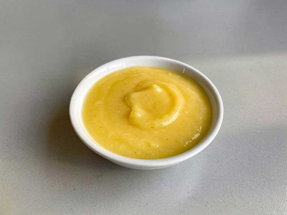Een wit schaaltje met zelfgemaalt lemoncurd.