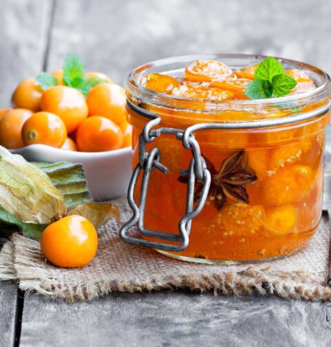 Physalis chutney in een open weckpot, met kaapse bessen ernaast.