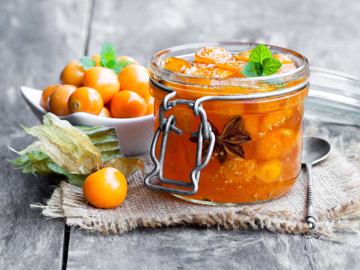 Physalis chutney in een open weckpot, met kaapse bessen ernaast.