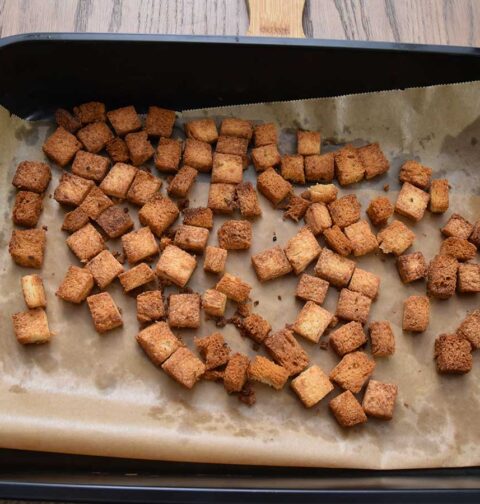 Een bakblik met zelfgemaakte croutons, die in een oven gemaakt zijn.