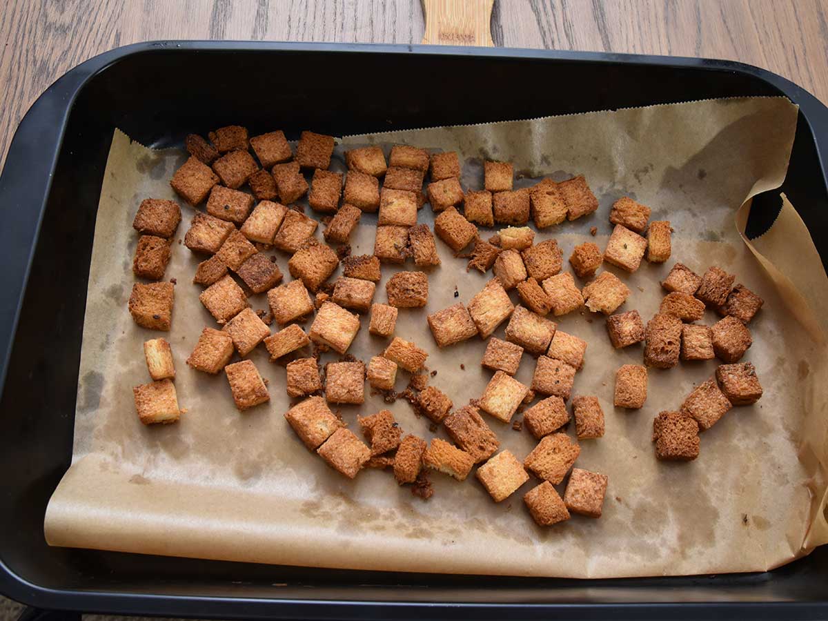 Een bakblik met zelfgemaakte croutons, die in een oven gemaakt zijn.