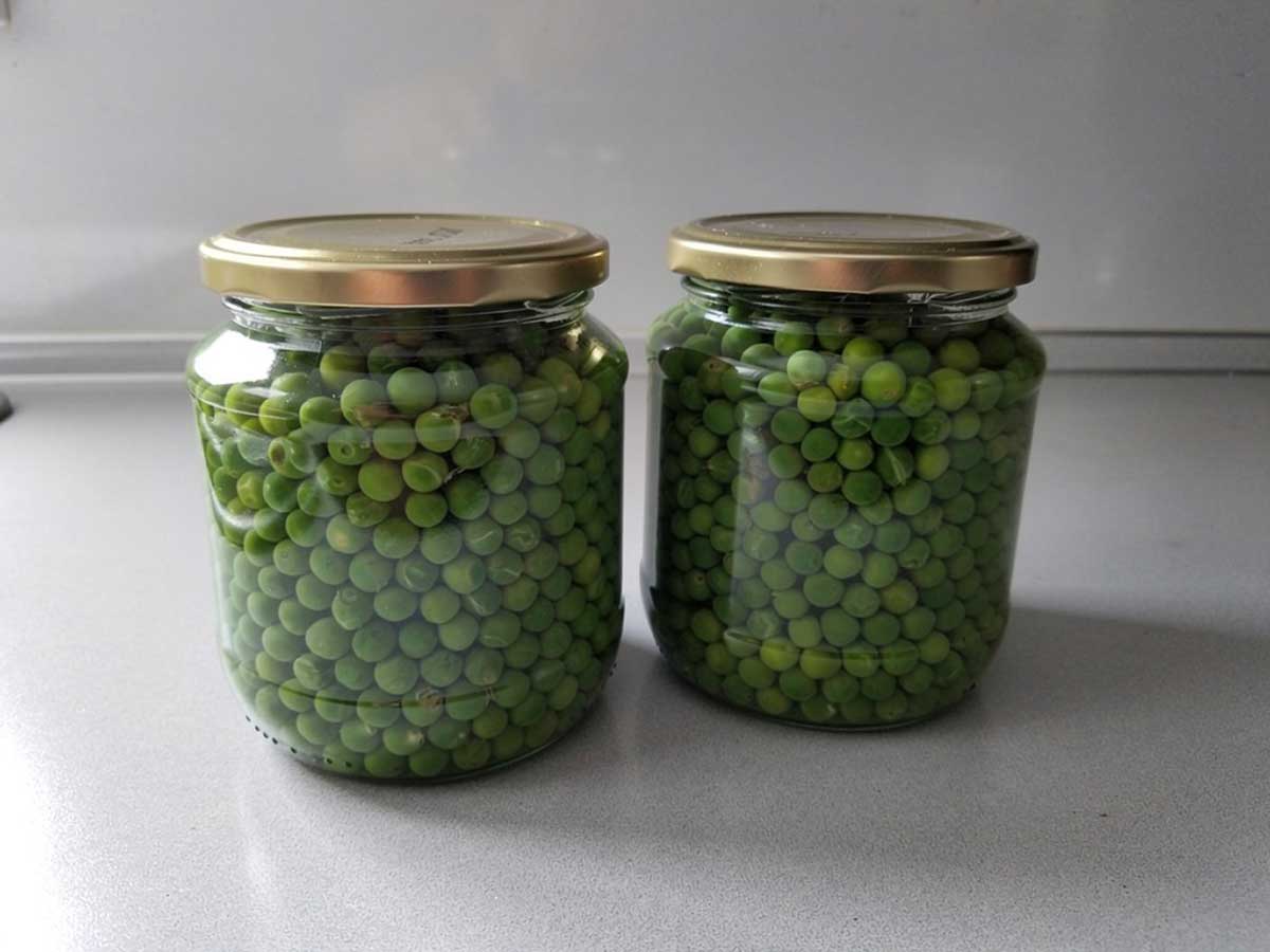 2 grote weckpotten met geweckte doperwten.