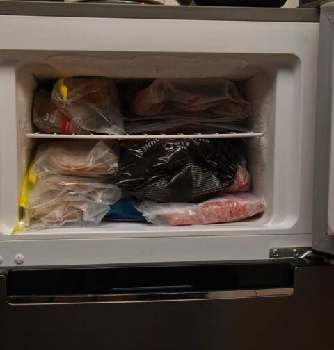 Een diepvriesvak met brood en diverse anders ingevroren levensmiddelen.