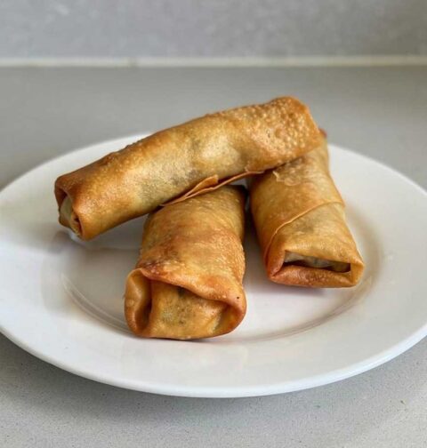 3 gebakken loempia's op een wit bordje.